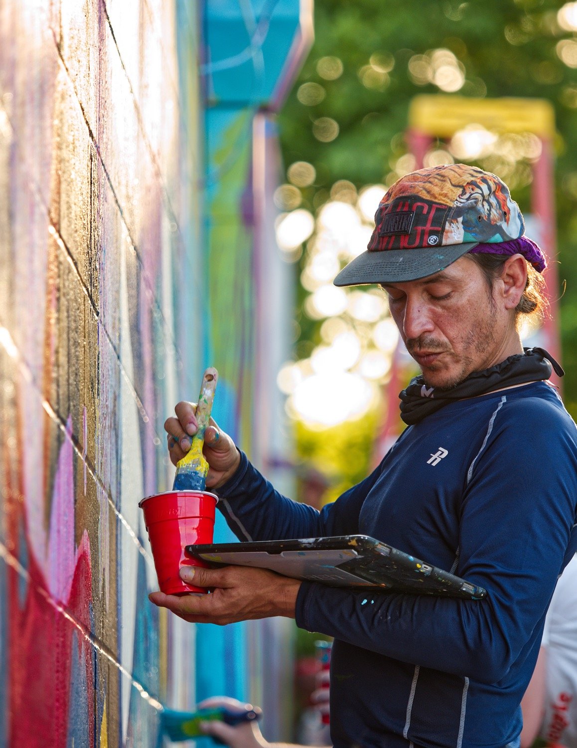 Miami muralist Luis Valle consults his design while painting the wall. [peruse more painting]